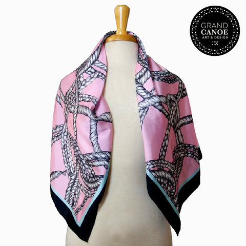 Square scarf with handed drawn braided motif in pink, black, teal and white. 36 inches by 36 inches satin charmeuse. 